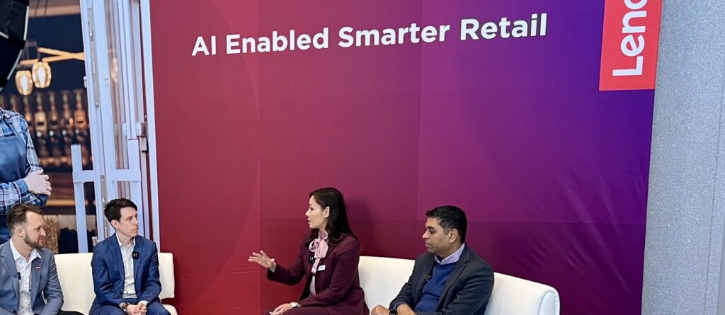 Female AI keynote speaker Susan Sly being interviewed by Lenovo at NRF in front of a backdrop reading AI Enabled Smarter Retail